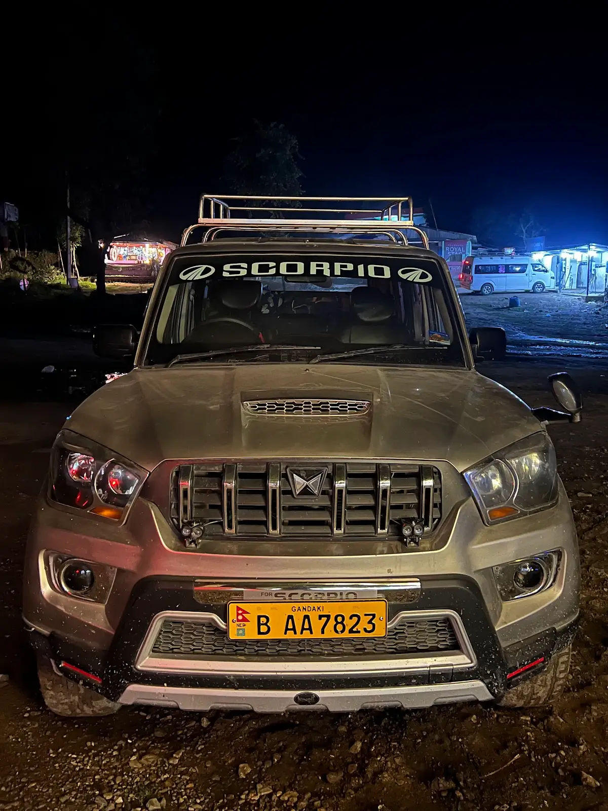 The Mahindra Scorpio at the Pokhara office at night — branded windshield.